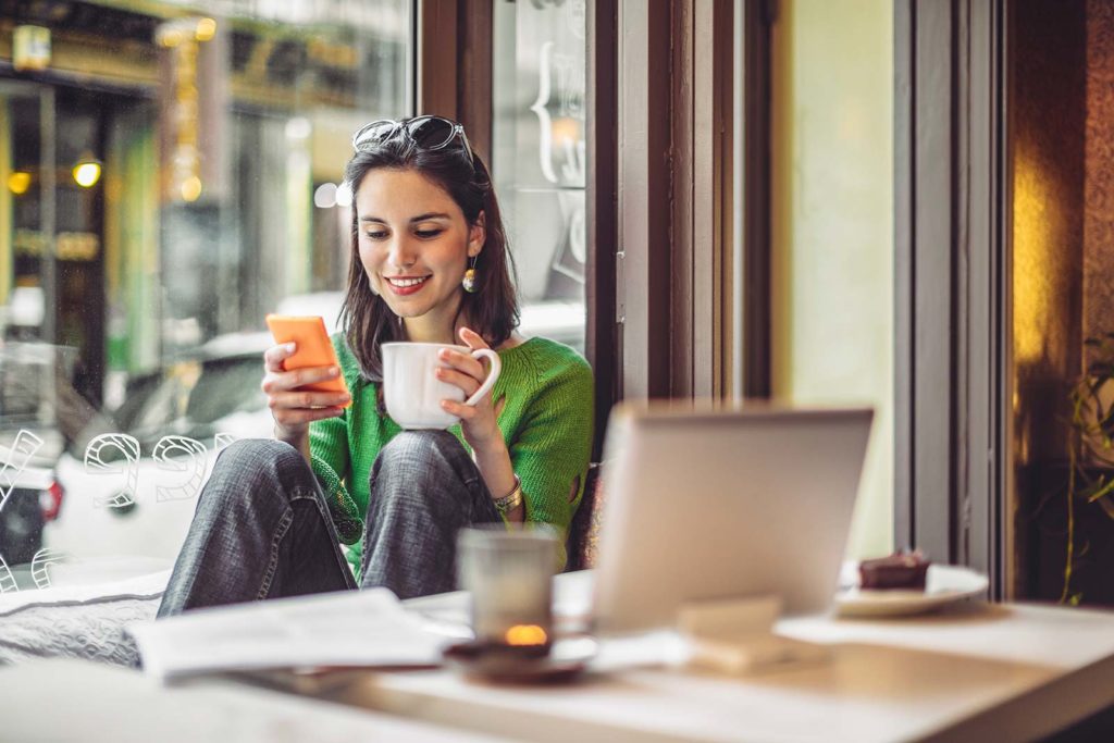 NATL_Pic_Adults_Woman_Cafe_Phone_Coffee_Laptop_Stock_iStock_859613042